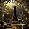 Elegant olive oil bottle under olive branches with golden lighting and tasting elements on a reflective table