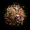 Luxurious floral herbal tea in a matte black pouch with botanical label, surrounded by loose dried flowers on a dark background