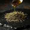 Mediterra Zaatar Edition No. 7 blend of wild thyme, sesame seeds, and sumac served with olive oil on dark stone