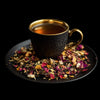 Steaming cup of Zhourat herbal tea with rose petals, chamomile, and Mediterranean botanicals
