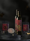 A display of Mediterra's leavantine vault, featuring two bottles of olive oil, Floral Reserve herbal tea, Maison Herb & Spice blend, and Za'atar Edition, arranged on a dark matte surface with a moody gray background.